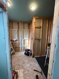 A room is being remodeled with wooden walls and a ladder.