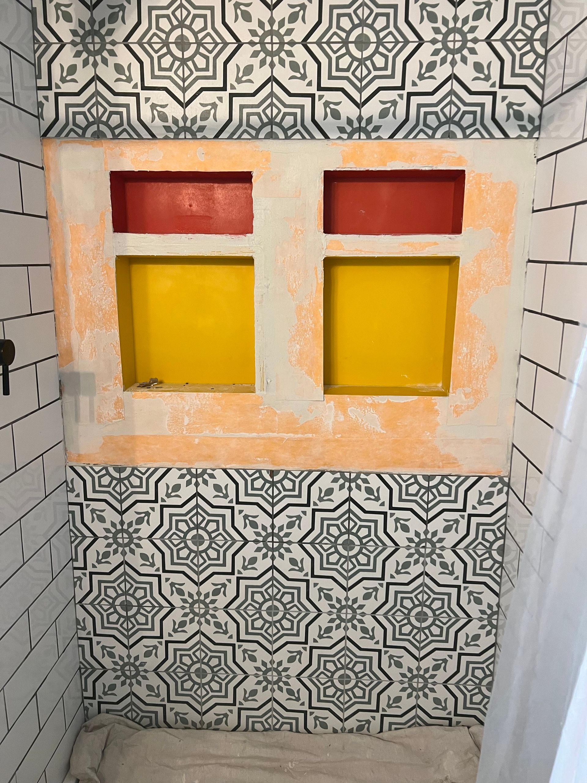 A bathroom with a stained glass window and tiles on the wall.