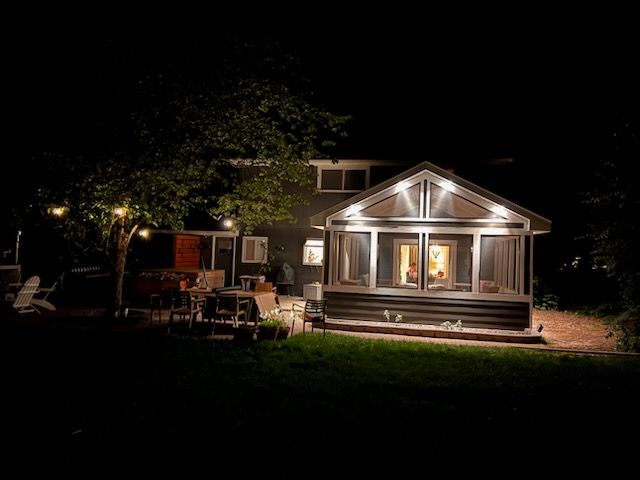 The backyard of a house is lit up at night.