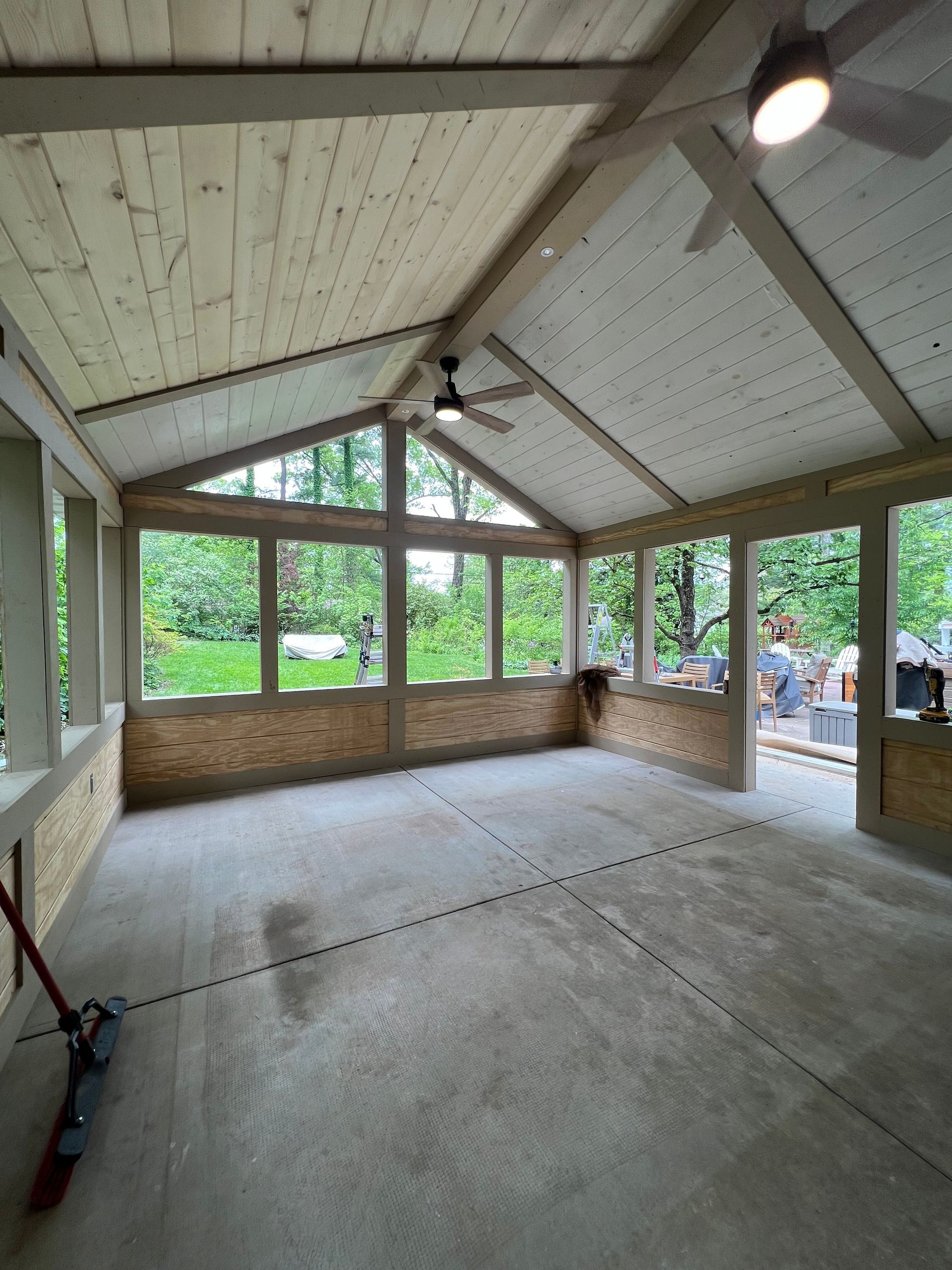 An empty room with a ceiling fan and a lot of windows
