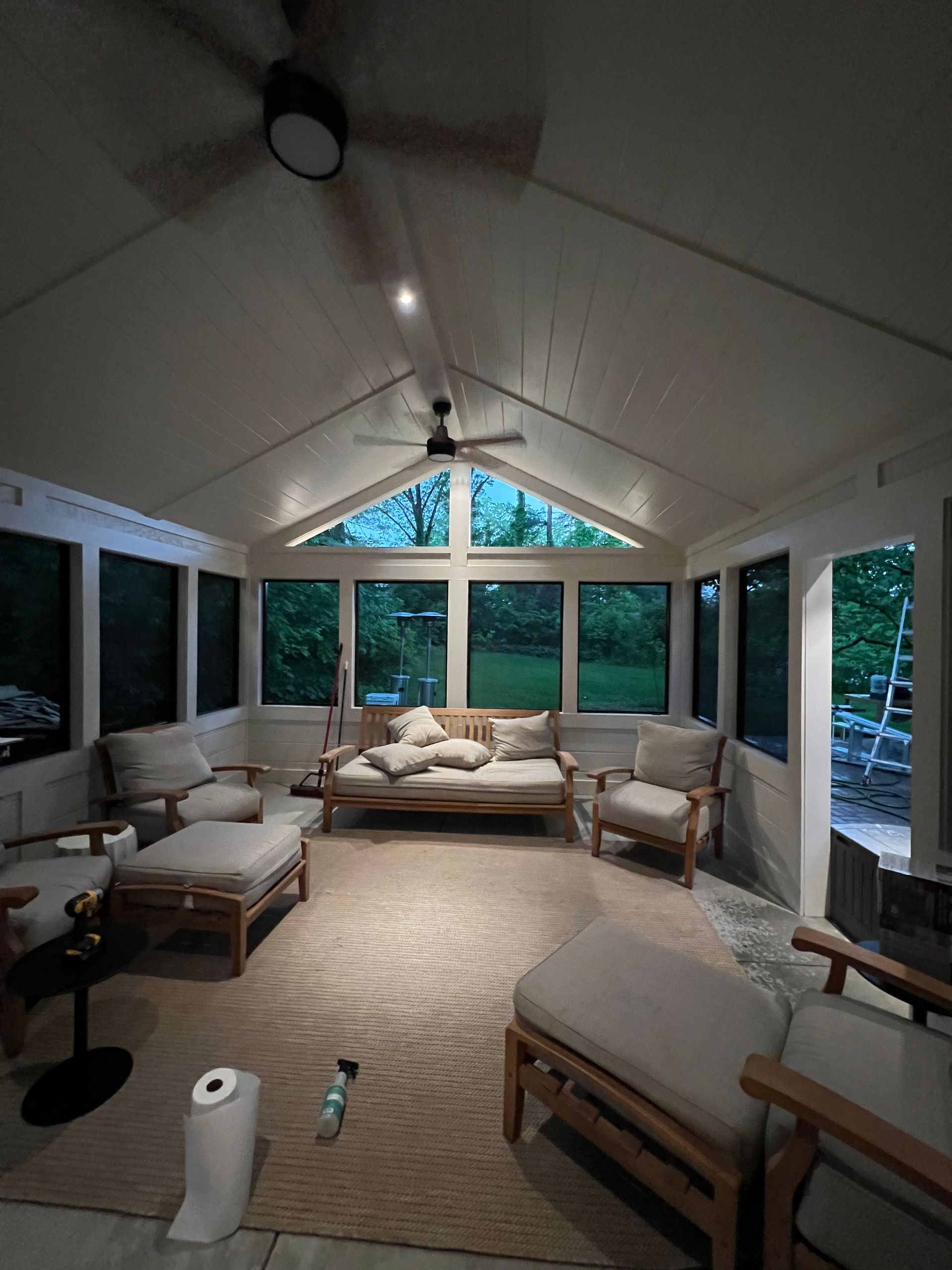 A living room with a couch and chairs and a ceiling fan
