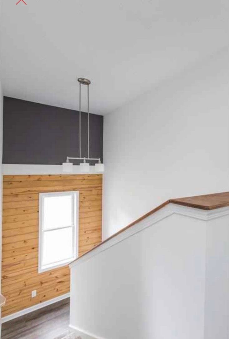 A staircase with a wooden wall and a window