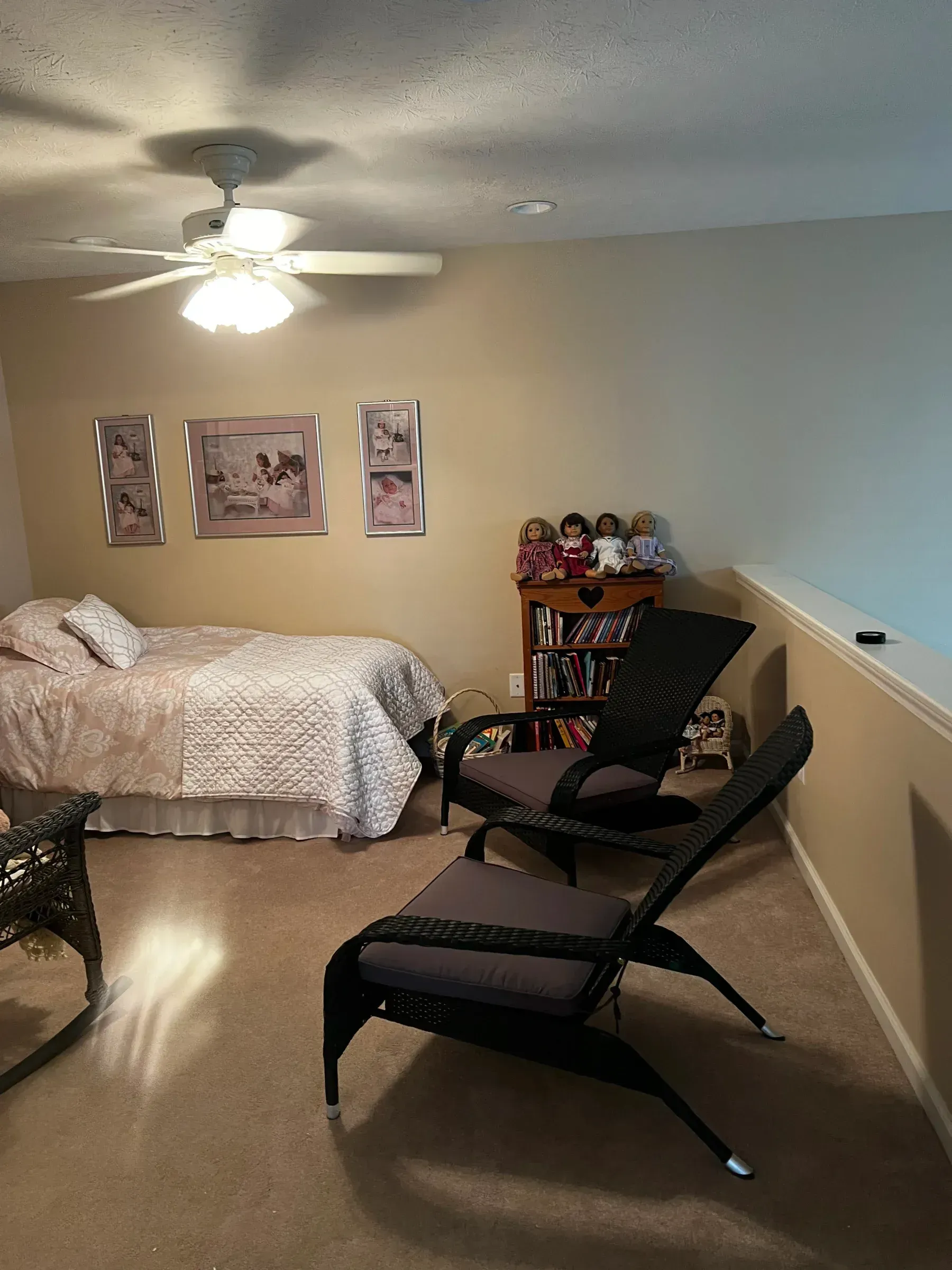 A bedroom with a bed , chairs and a ceiling fan.