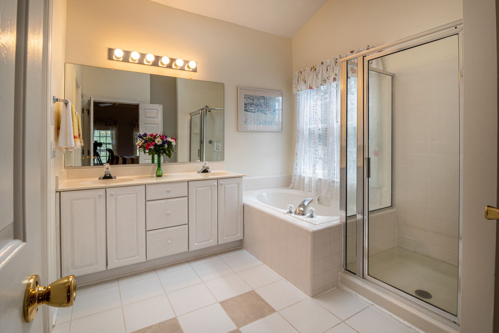 A bathroom with a tub , sink , mirror and shower.