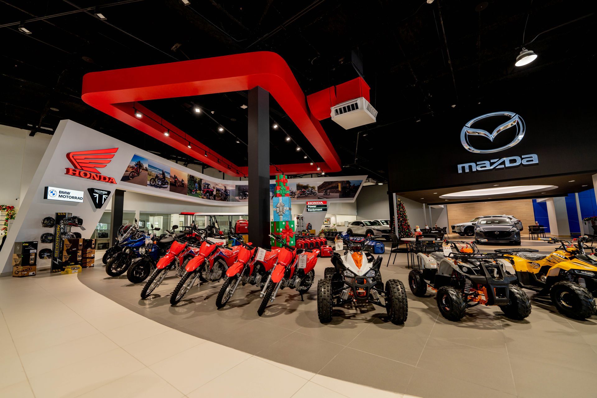A row of motorcycles and atvs are lined up in a showroom designed and built by DEV Builders.