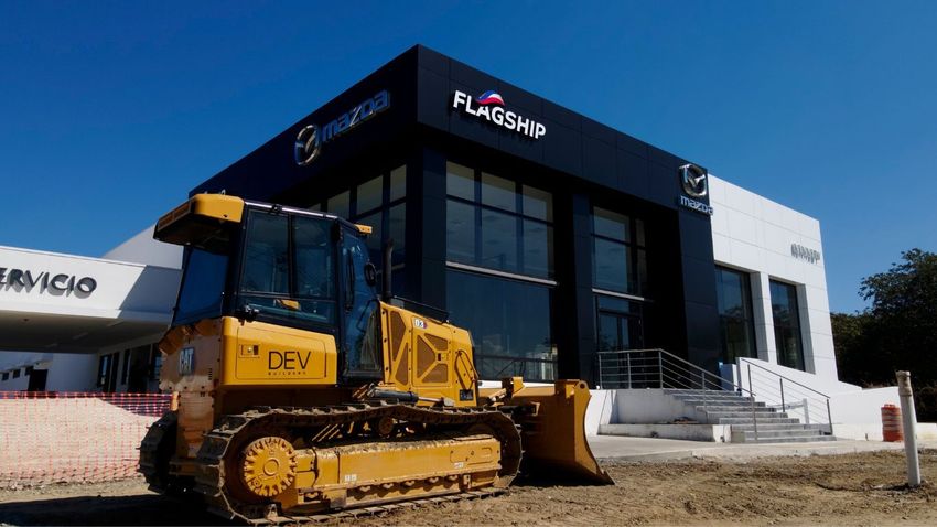 DEV Builders Heavy Machinery in front of a Car dealership under construction 