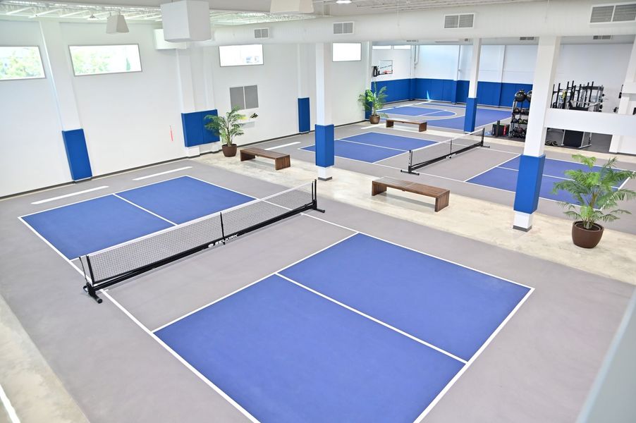 A large indoor Picket Ball court with blue and white courts built by DEV Builders