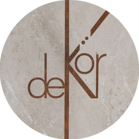 Logo with "dekor" in brown, with a vertical and diagonal line on a stone-like circle.