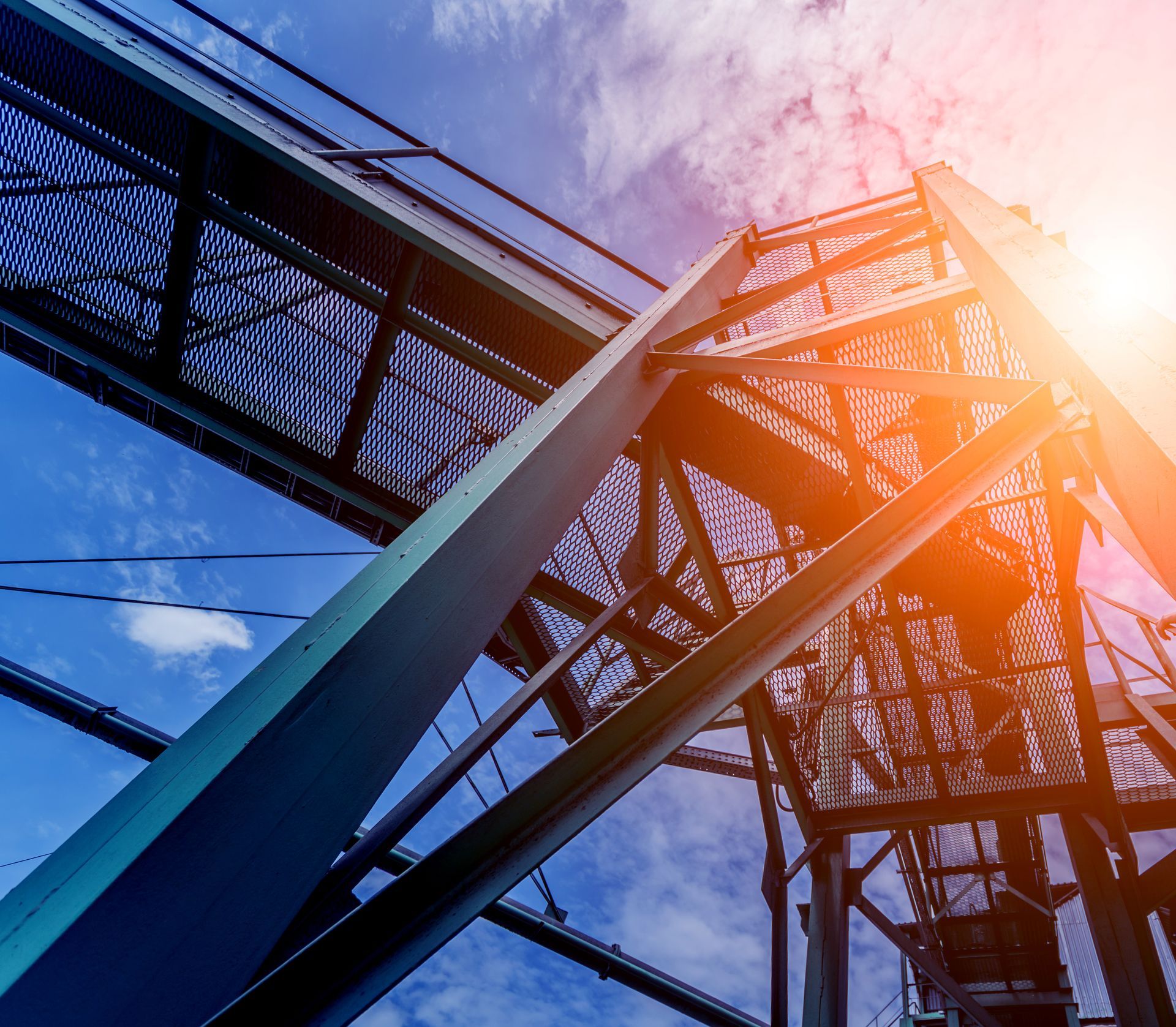 Two construction workers cutting metal with a saw, sparks flying, indoor setting.
