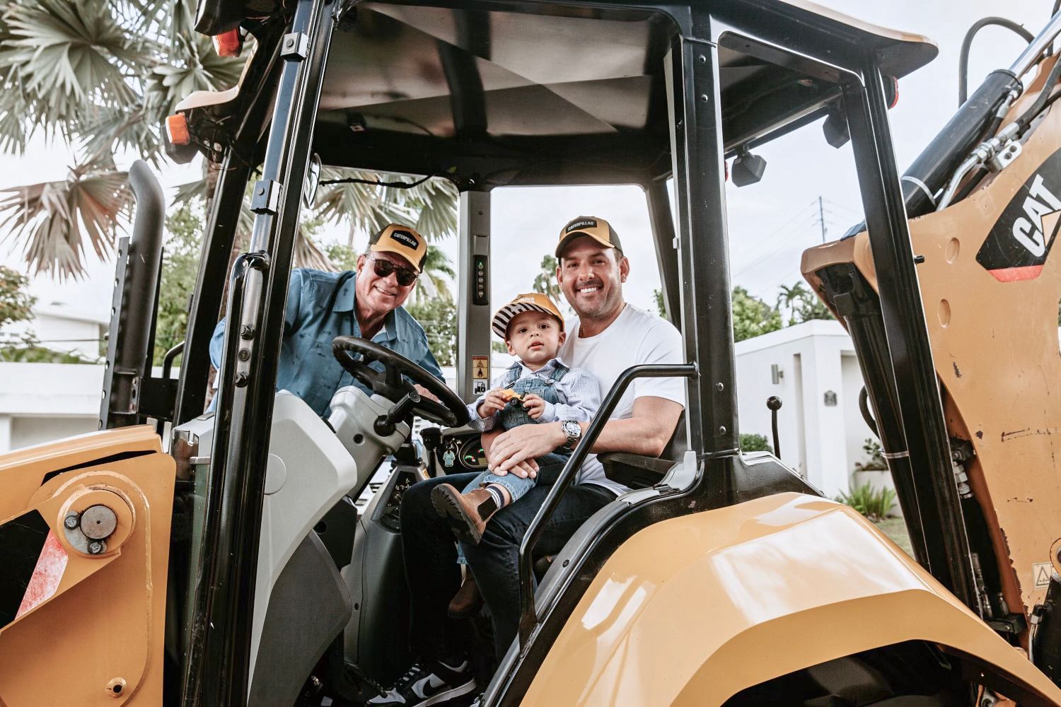 Ricardo de Varona Sr., Ricardo de Varona Jr., and his son are sitting on a tractor.