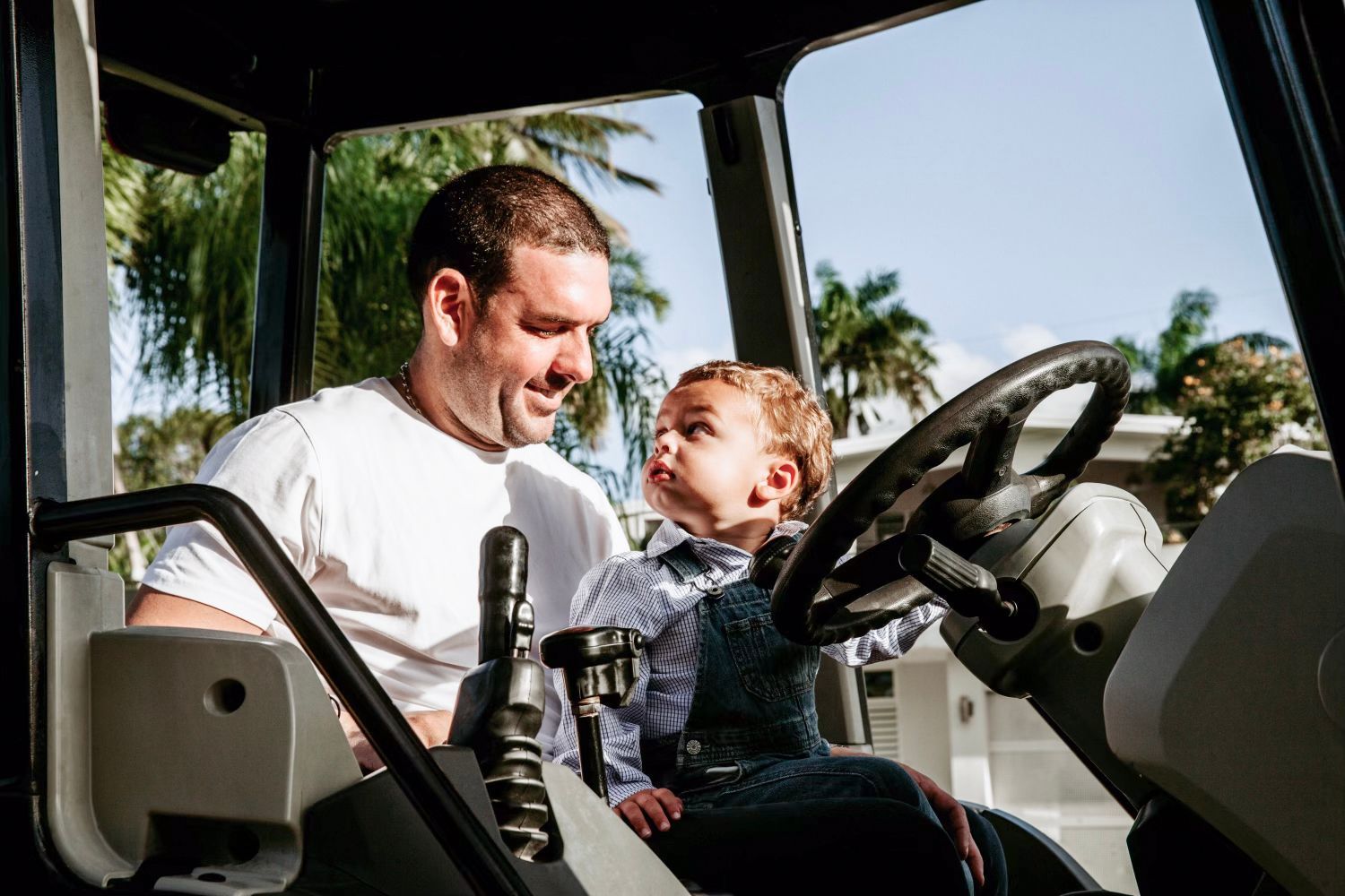 Ricardo de Varona Jr. and his son sitting on a tractor.