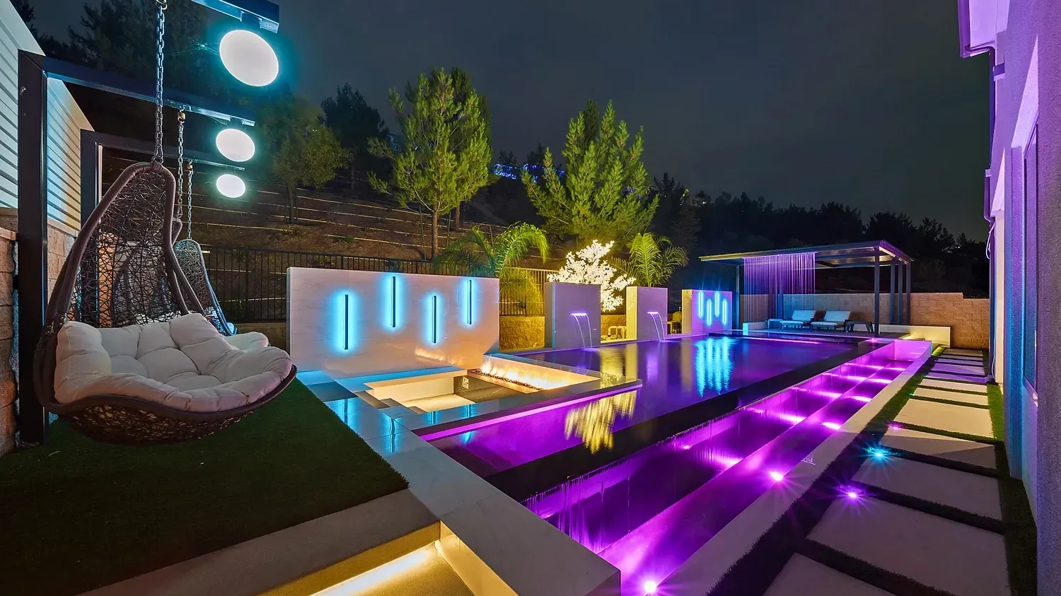 Luxury outdoor living space with custom pool and swings in Lake Forest, CA.