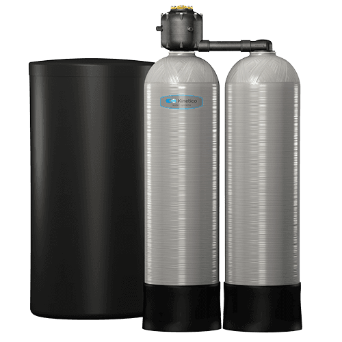 A water softener is sitting next to a black tank.