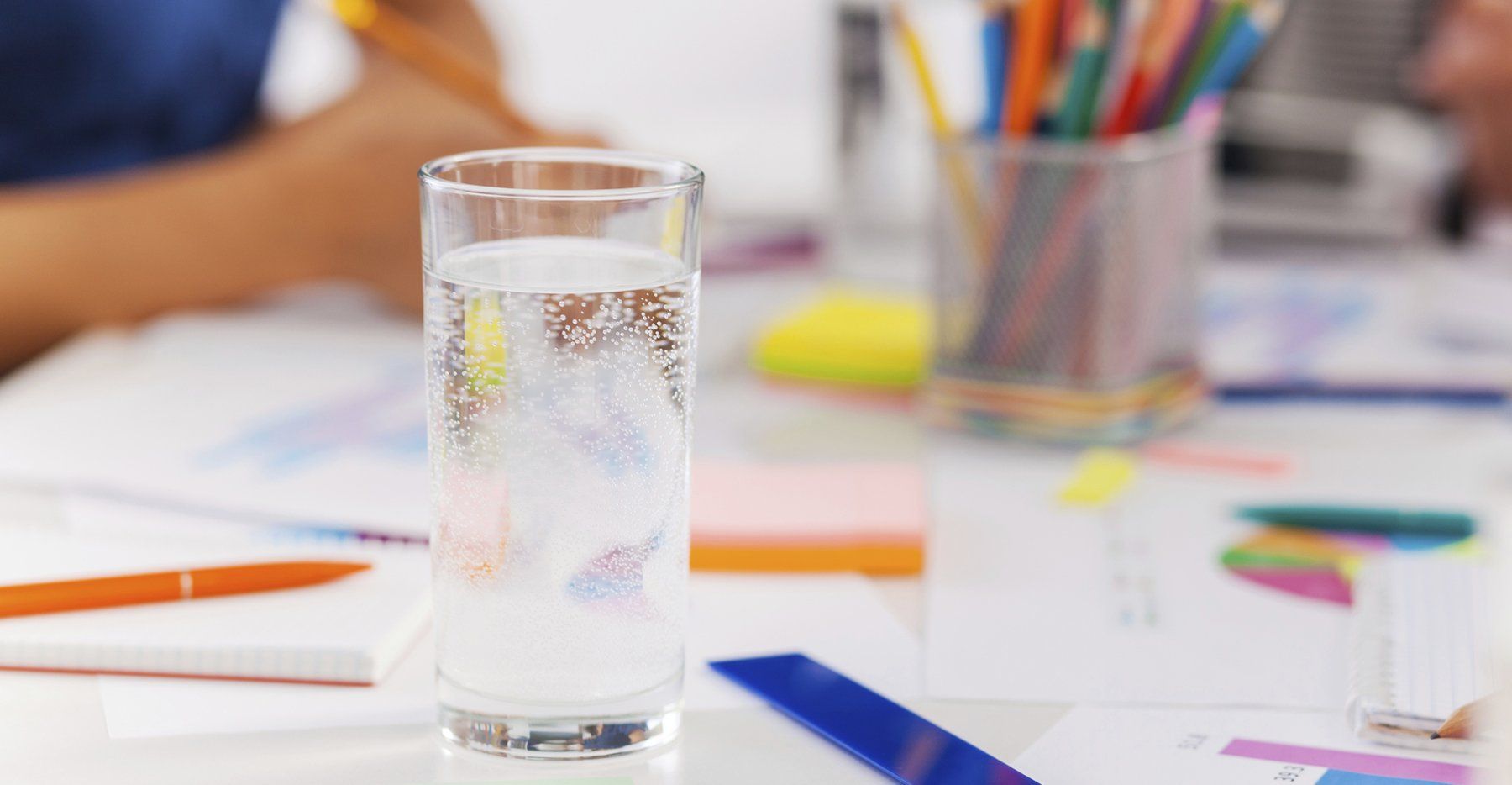 A glass of water is sitting on a table.