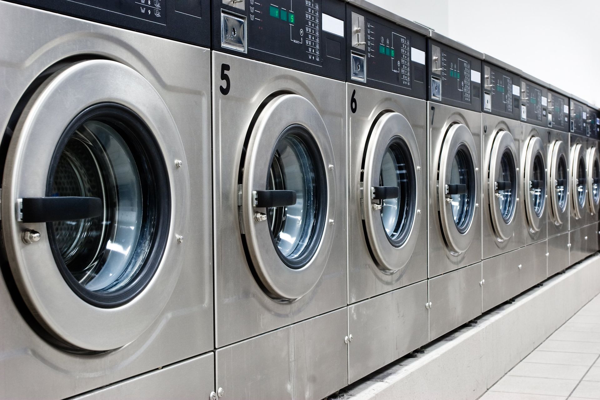 A row of washing machines in a laundromat with the number 5 on them