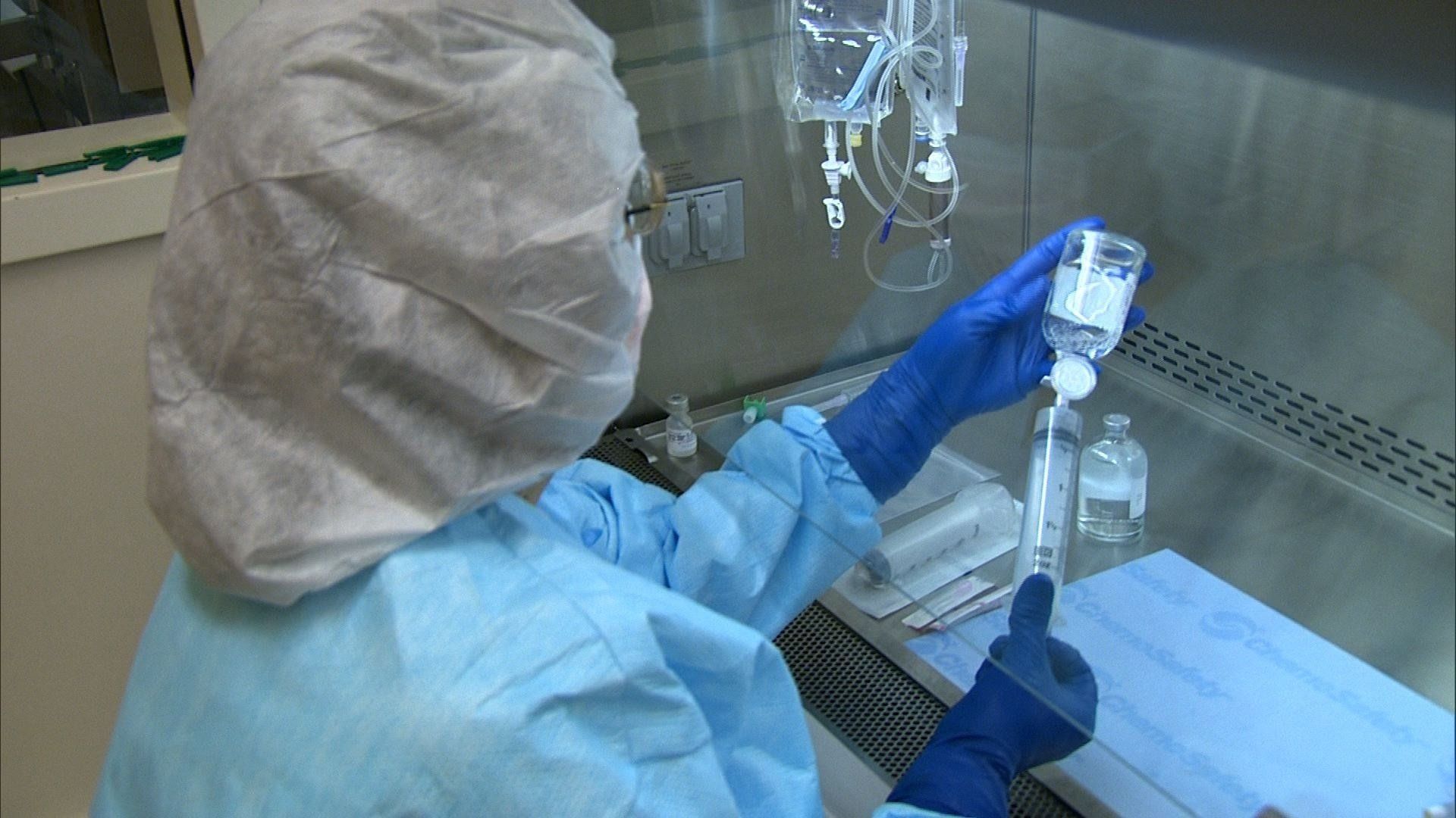 A scientist is working in a clean room in a lab.