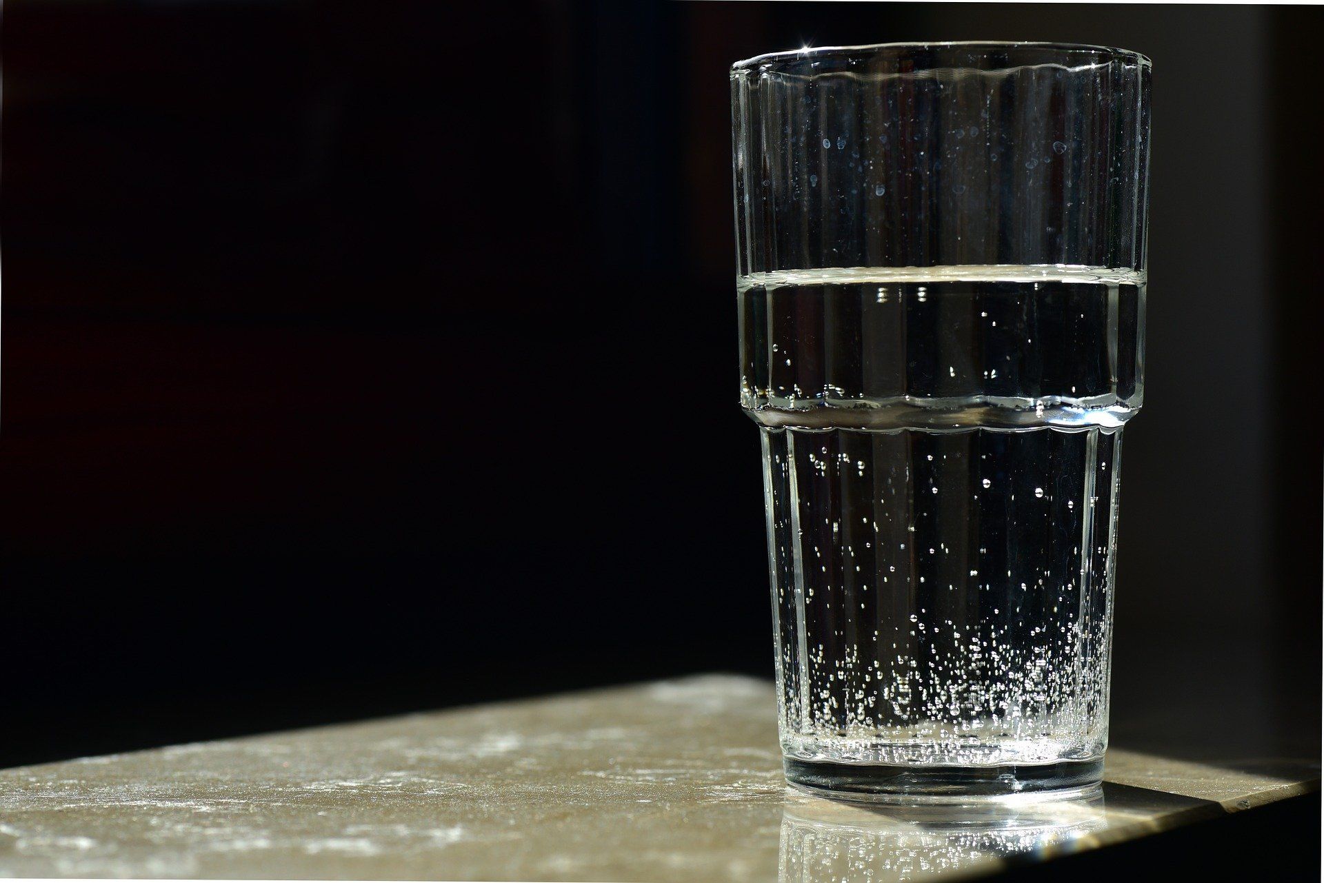 A glass of water is half full on a table