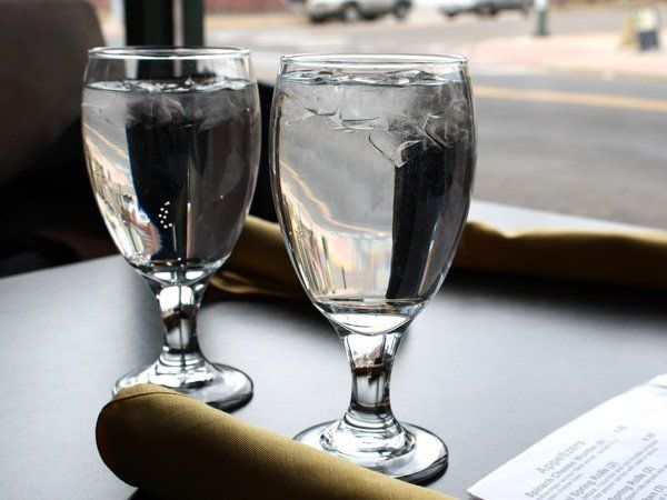 Two wine glasses on a table next to a napkin