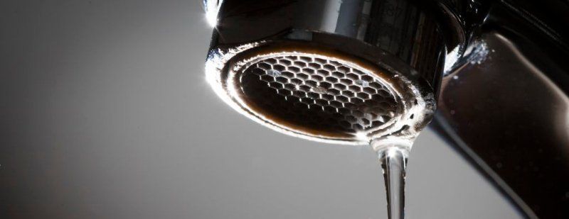 A close up of a faucet with water dripping from it.