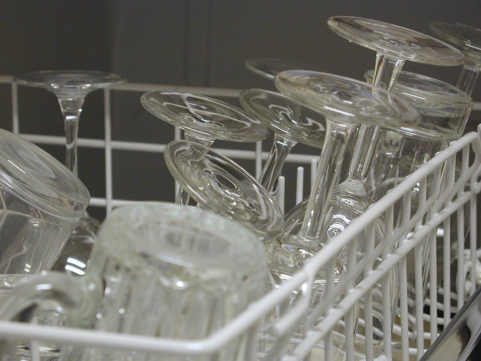 A dishwasher full of wine glasses and cups