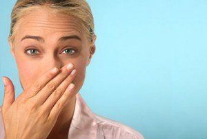 A woman is covering her mouth with her hand.