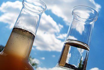 Two beakers filled with different colored liquids are sitting next to each other.