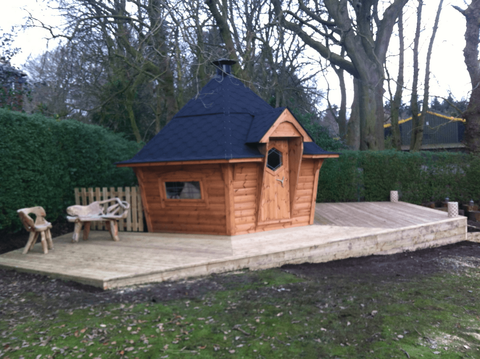 timber birdhouse style garden shed on decking