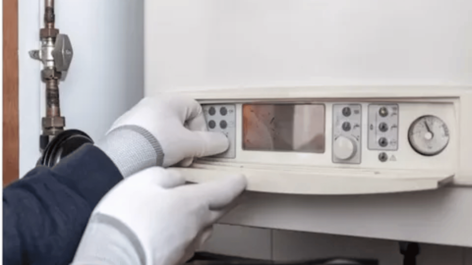 A person wearing white gloves is working on a boiler.