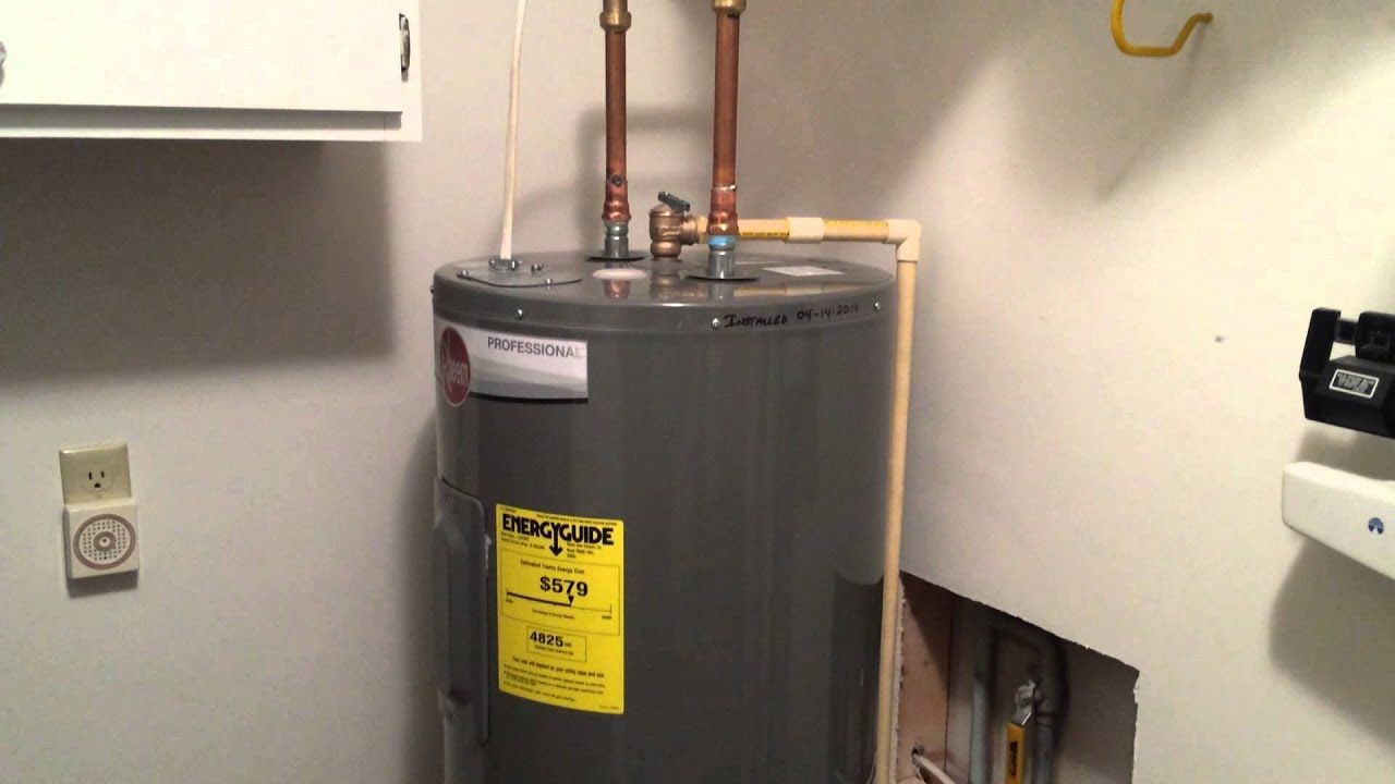 A gray water heater with a yellow sticker on it