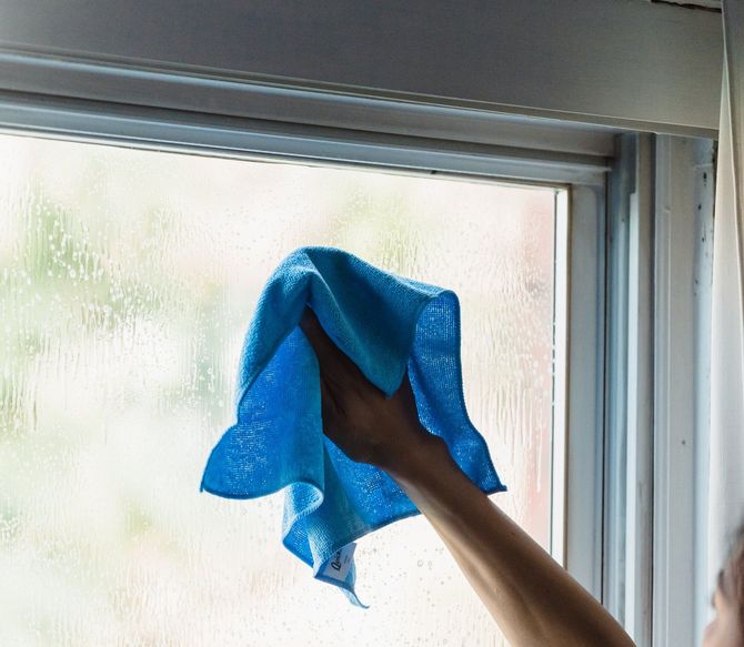 cleaning a window with a rag