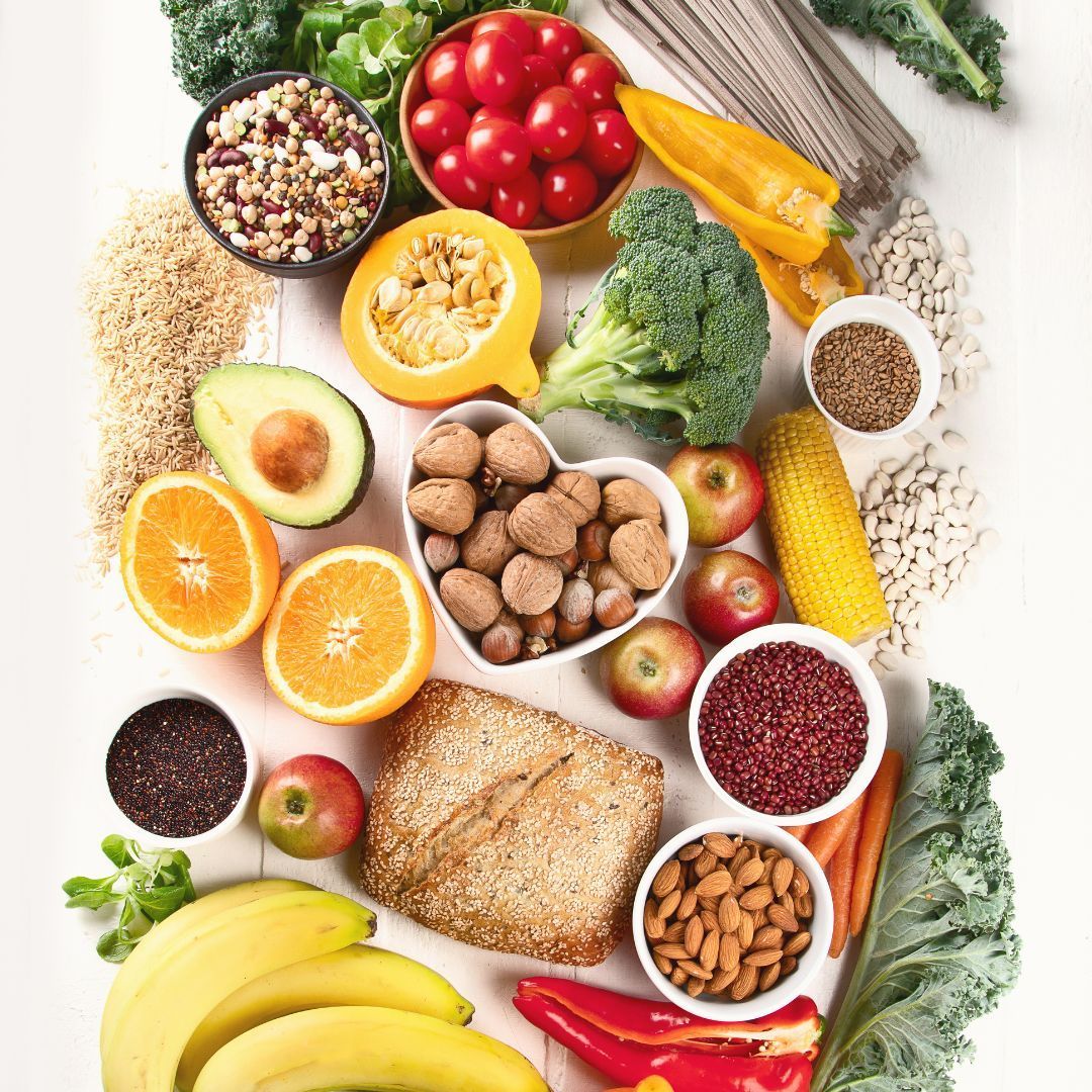 A variety of fruits and vegetables are arranged in a circle on a table.