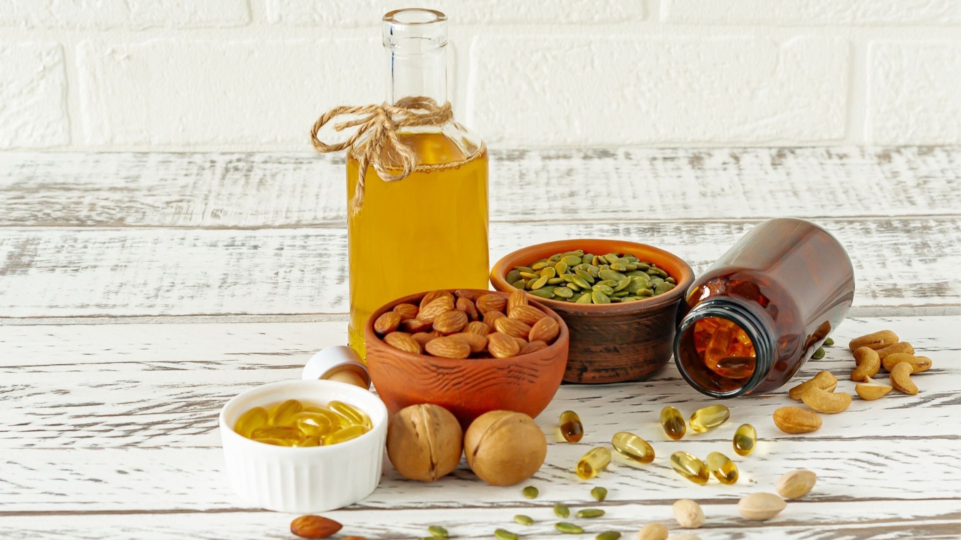 A wooden table topped with bowls of nuts and oils.