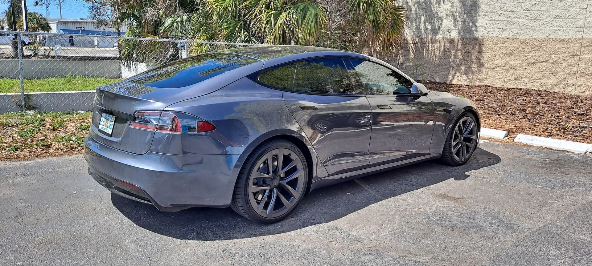 Gray Tesla parked on asphalt.