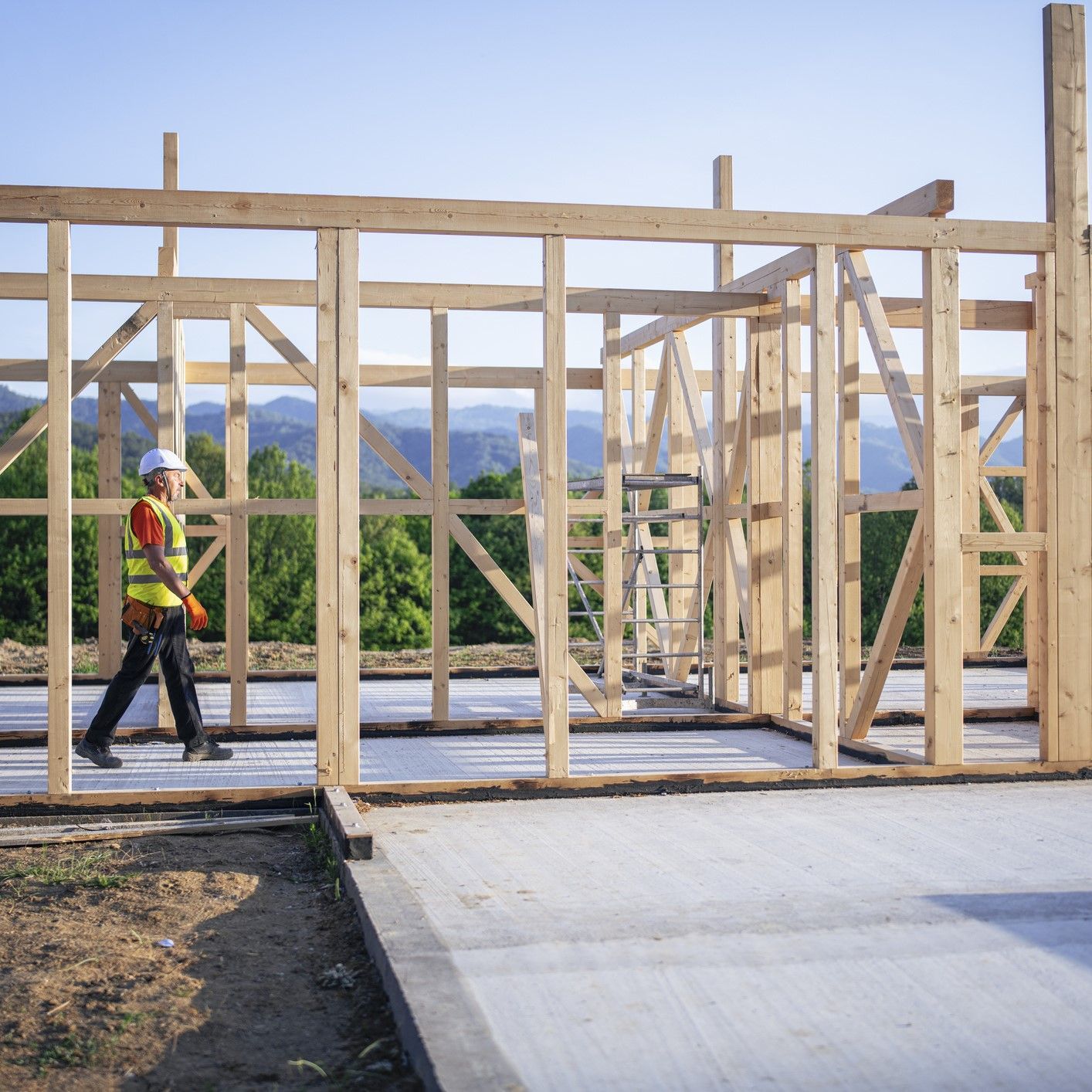 Home construction site with contractor reviewing building plans in Los Angeles.