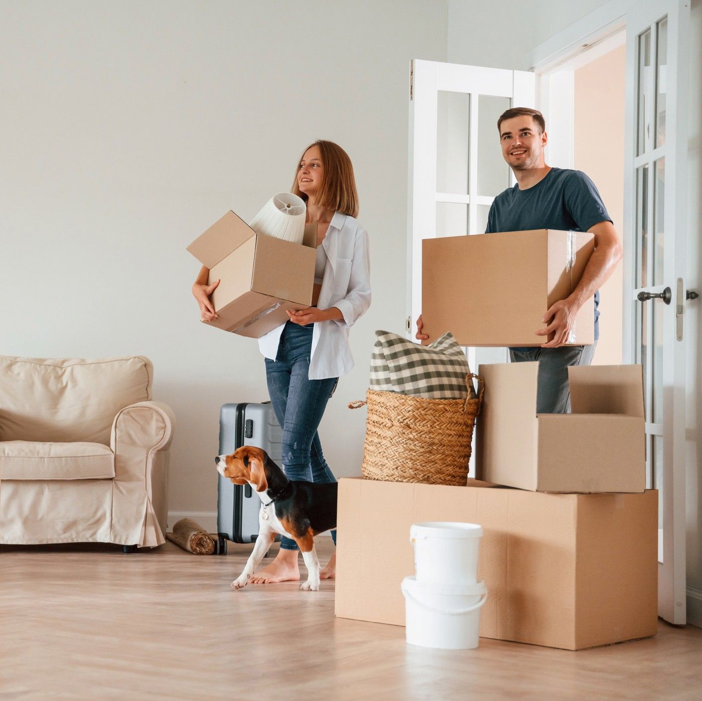 Young couple with boxes moving into new SB8 housing with dog.