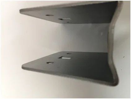 A metal U-shaped bracket with two rectangular cutouts and circular holes on each side, shown from a top-down angle.