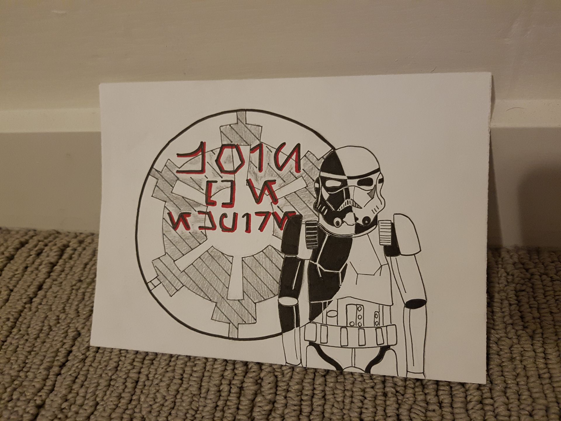 Stormtrooper drawing in black and white, standing next to a symbol with text in red.