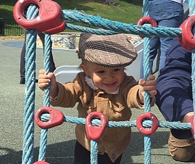 A little boy in an american flag outfit is standing on the beach