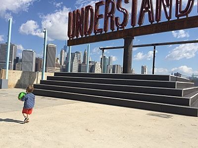 A little boy is standing in front of a sign that says understand.