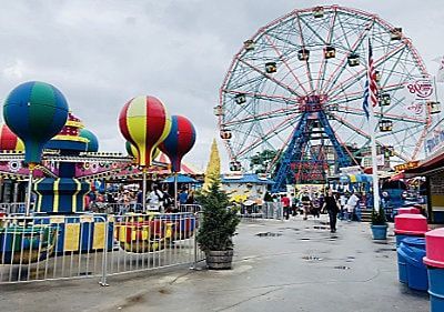 A carnival with a ferris wheel and hot air balloons.
