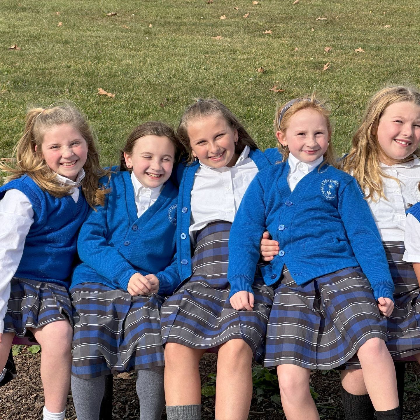 Five students smiling on the playground during recess