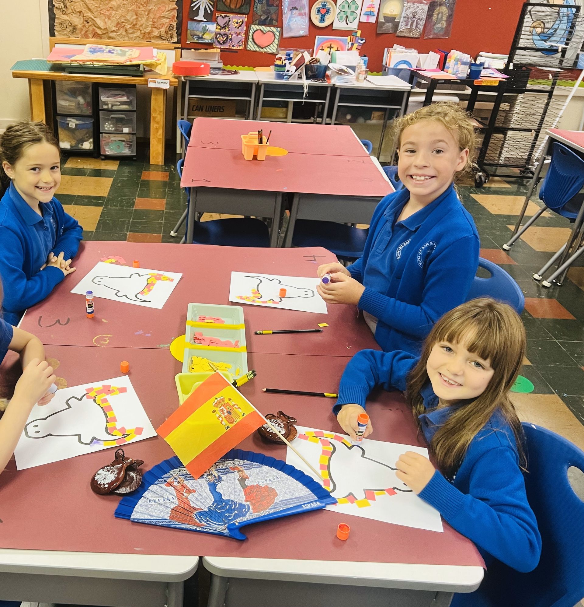 A group of children are playing with red cups on a table.