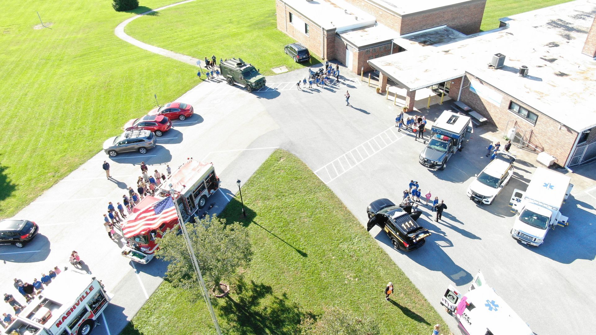 Aerial view of emergency vehicles and people gathered at a school.