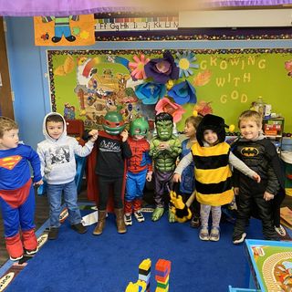 A group of children are posing for a picture with a police officer and a police shield.