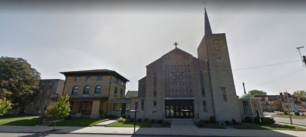 A large church with a steeple in the middle of a city.