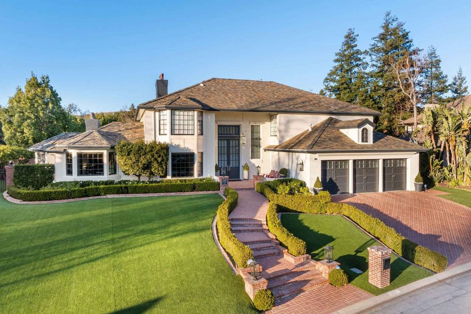 Large two-story suburban house with a manicured lawn, curved walkway, and landscaped front yard Large two-story suburban house with a manicured lawn, curved walkway, and landscaped front yard
