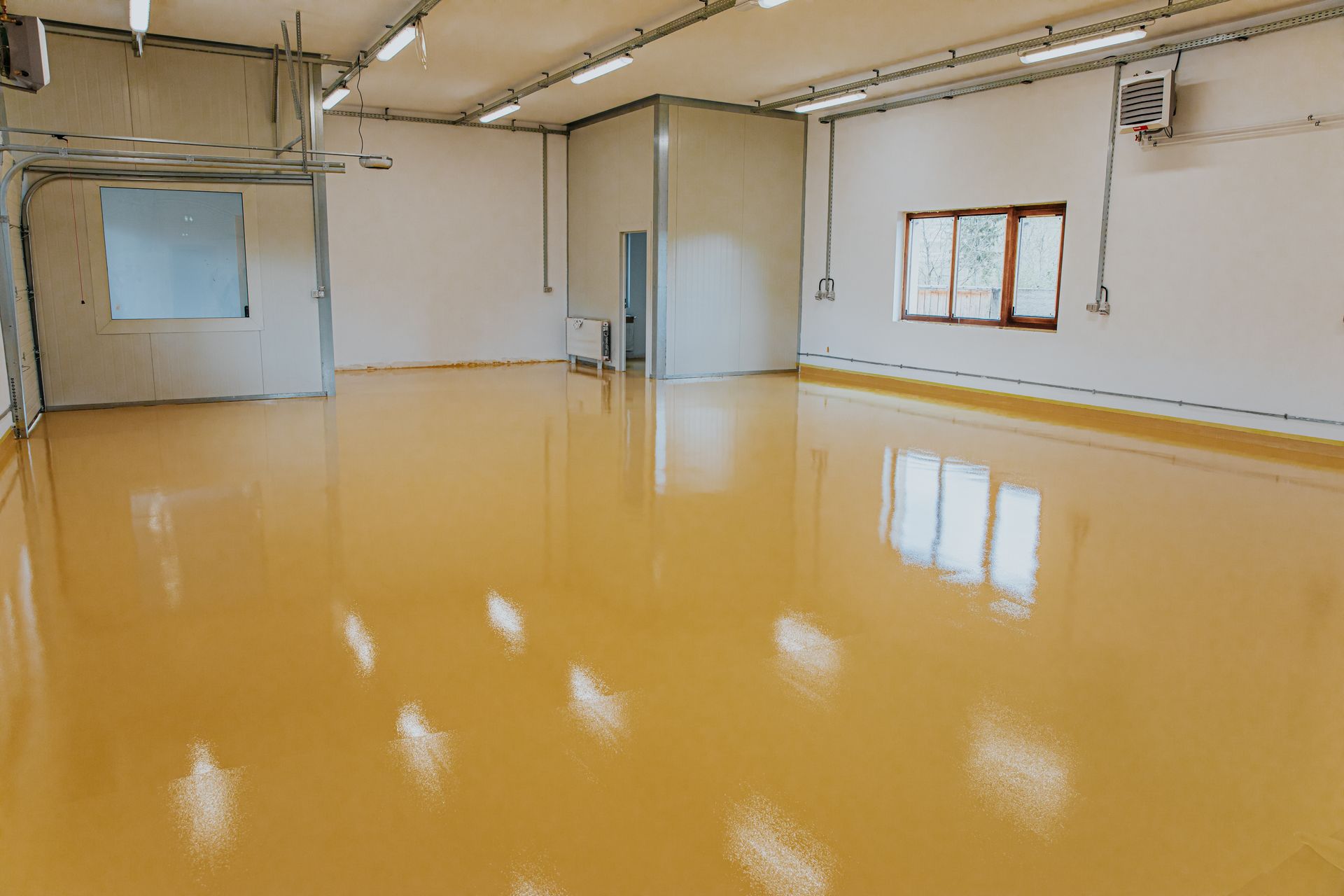 A dark yellow epoxy resin applied to the floor of an industrial hall.