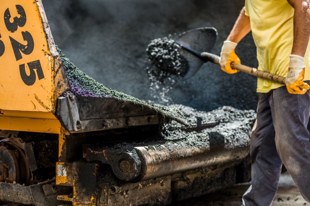 A Man is Working on a Road With a Shovel — Rowdraulics NQ Pty Ltd In Mount Louisa, QLD