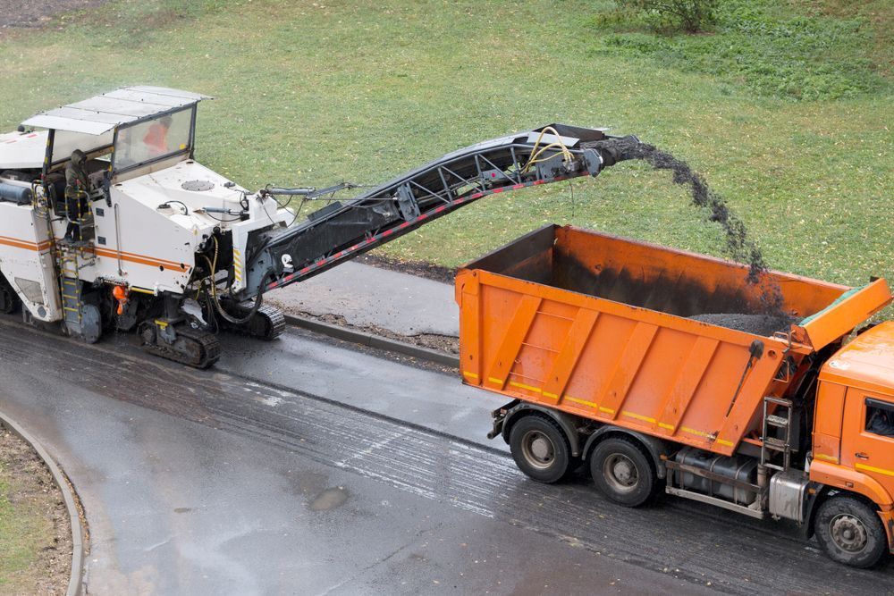 A Dump Truck is Being Loaded With Asphalt by a Machine — Rowdraulics NQ Pty Ltd In Mount Louisa, QLD
