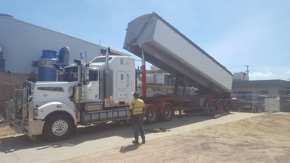 Man Is Standing Next To A Dump Truck Which Is Unloading Goods — Rowdraulics NQ Pty Ltd in Mackay, QLD